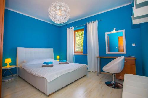 1 dormitorio azul con 1 cama y 1 silla en Villa Mirna, en Novaki Pazinski