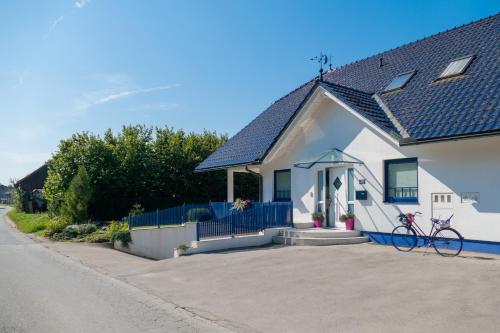 a white house with a bike parked in the driveway at Modrin Apartments in Kamnik