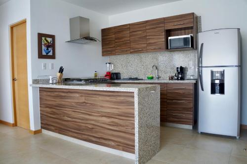 a kitchen with a white refrigerator and wooden cabinets at Metropolitan Suites in Guadalajara