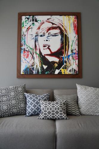 a painting on the wall above a couch with pillows at Metropolitan Suites in Guadalajara