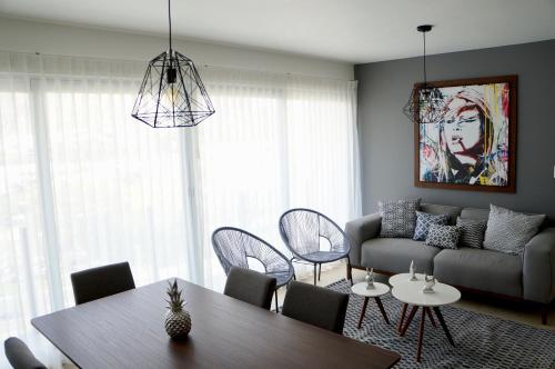 a living room with a couch and a table and chairs at Metropolitan Suites in Guadalajara