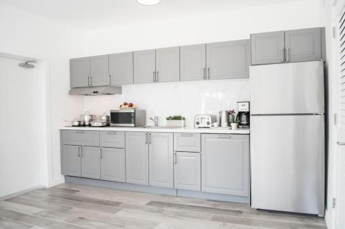 a kitchen with white cabinets and a refrigerator at Sobe Lux in Miami Beach