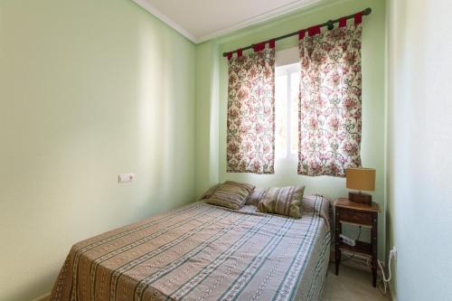 - une petite chambre avec un lit et une fenêtre dans l'établissement Columbretes, à Alicante