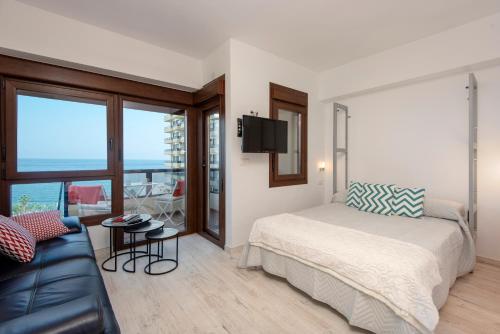 a bedroom with a bed and a couch at ALOHA 804 in Benalmádena