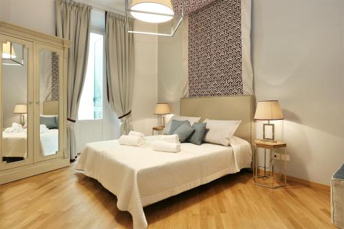 a bedroom with a bed with white sheets and pillows at Tornabuoni Boutique in Florence