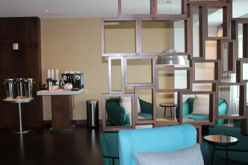 a living room with a blue chair and mirrors at Radisson Blu Mall of America in Bloomington