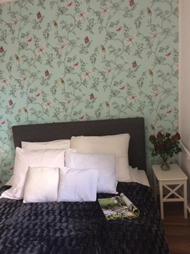 1 dormitorio con 1 cama y papel pintado con motivos florales en Apartament Pod sanockim zamkiem, en Sanok