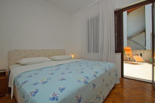 1 dormitorio con 1 cama, 1 silla y 1 ventana en Hella Apartments, en Trogir