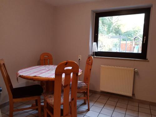 uma sala de jantar com uma mesa e cadeiras e uma janela em 2 Zi-Appartment mit Gartennutzung em Brühl