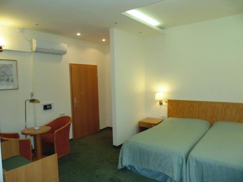 a hotel room with a bed and a table and a chair at Curtea Brasoveana in Braşov