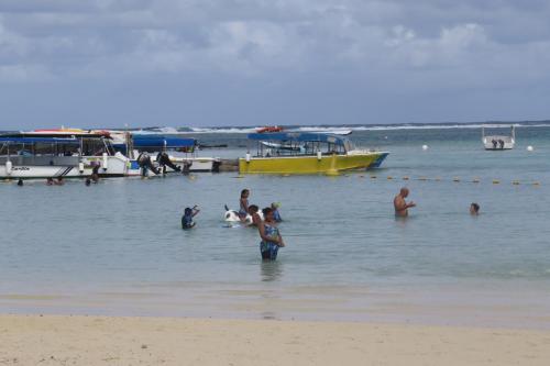 a group of people in the water at the beach at Sacha Tourist Residence 2 in Mahébourg