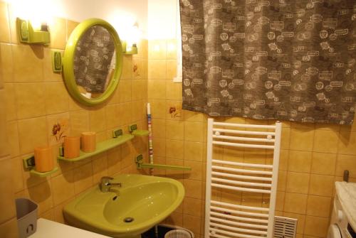 La salle de bains est pourvue d'un lavabo vert et d'un miroir. dans l'établissement Ti ar Rozenn, à Mont-Dol