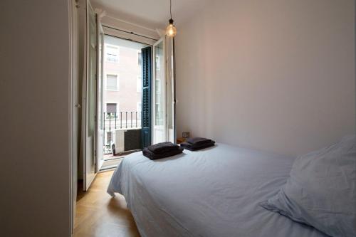 ein Schlafzimmer mit einem Bett mit zwei schwarzen Handtüchern darauf in der Unterkunft Chueca Just For You in Madrid
