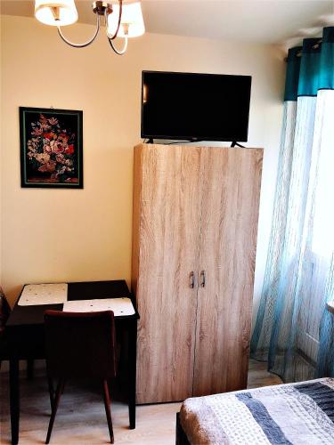 a room with a desk and a cabinet with a television on it at Chrobrego 269 in Biała Podlaska
