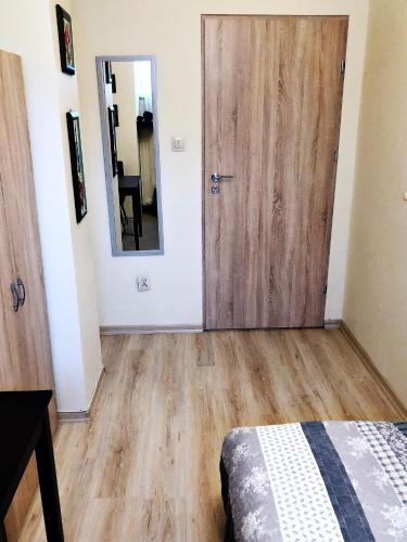 a bedroom with a wooden door and a mirror at Chrobrego 269 in Biała Podlaska