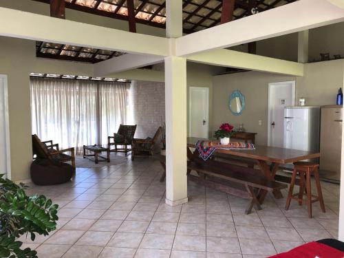 a living room with a table and a kitchen at Hospedaria Aconchego in Santa Teresa