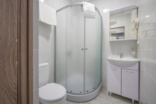 Un baño blanco con inodoro y lavabo. en ASIA Hotel, en Almaty