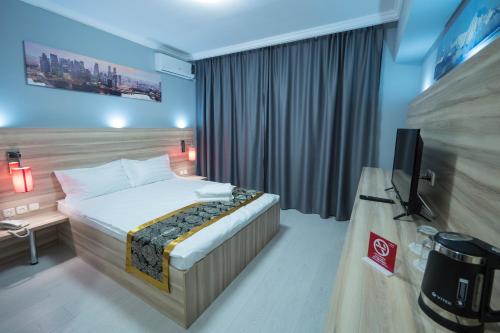 a hotel room with a bed and a television at ASIA Hotel in Almaty