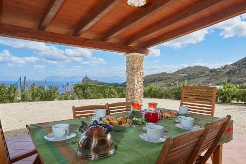 a table with a teapot on it on a patio at Villa Ninetta in Scopello