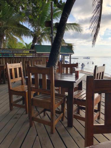 a wooden table and chairs on the beach at Bananarama Dive & Beach Resort in West Bay