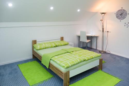a bedroom with a bed with green rugs and a desk at Modrin Apartments in Kamnik