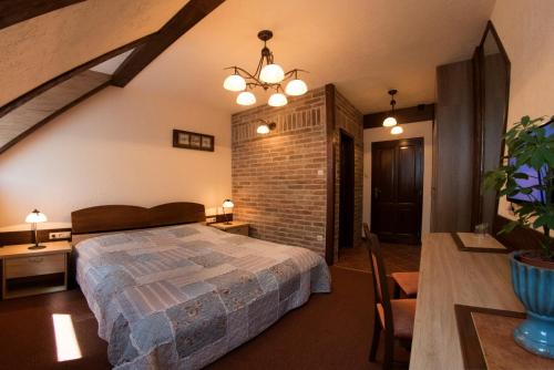a bedroom with a bed and a brick wall at Família Vendégház in Szeged