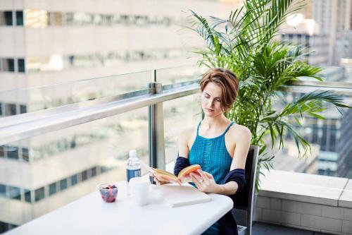 a woman sitting at a table reading a book at Hotel Boutique at Grand Central in New York