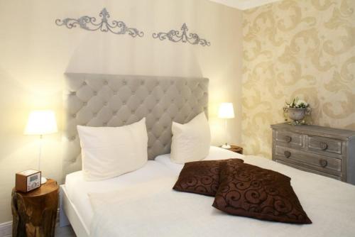 - une chambre avec un grand lit blanc et une grande tête de lit dans l'établissement "Rieke", à Westerland