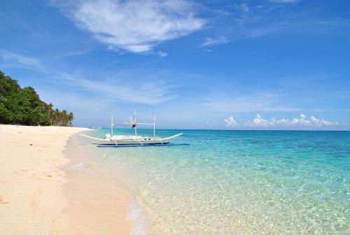 a boat sitting on the shore of a beach at Surfside Boracay Resort in Boracay