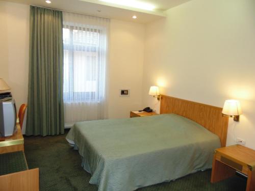 a hotel room with a bed and a window at Curtea Brasoveana in Braşov