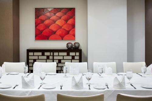 a meeting room with a table with white chairs and a painting at Hotel Boutique at Grand Central in New York