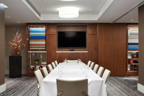 une salle de conférence avec une table, des chaises et une télévision dans l'établissement Hotel Boutique at Grand Central, à New York