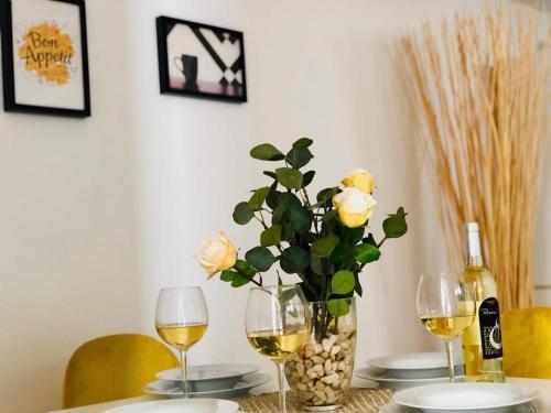 a table with two glasses of wine and a vase with roses at Canaryislandshost l Lovely Lanzarote in Nazaret