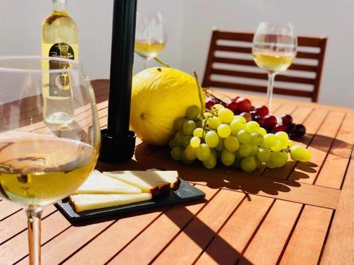 a table with two glasses of wine and a bunch of grapes at Canaryislandshost l Lovely Lanzarote in Nazaret