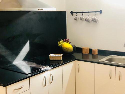 a kitchen with a black counter top and a sink at Canaryislandshost l Lovely Lanzarote in Nazaret