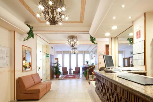 an office with a reception desk with a laptop on a counter at Hotel Terminus & Plaza in Pisa