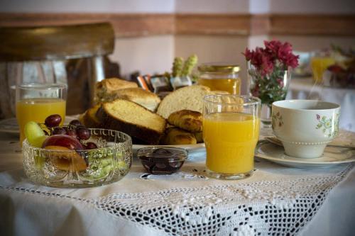 a table with a plate of bread and two glasses of orange juice at Nives in Nimfaíon