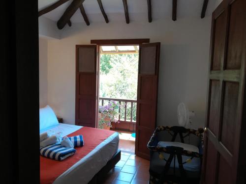 a bedroom with a bed and a door and a window at Alojamiento El Retiro Barichara in Barichara