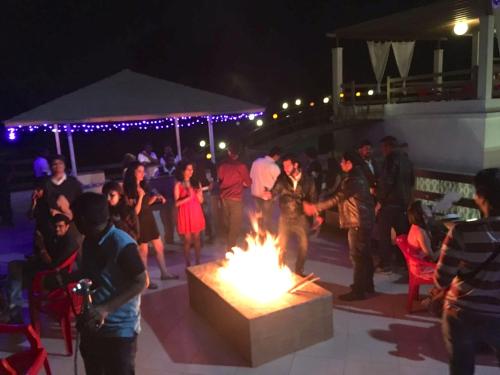 a group of people standing around a fire pit at night at CASA DIOS Luxury Villas in Khandala