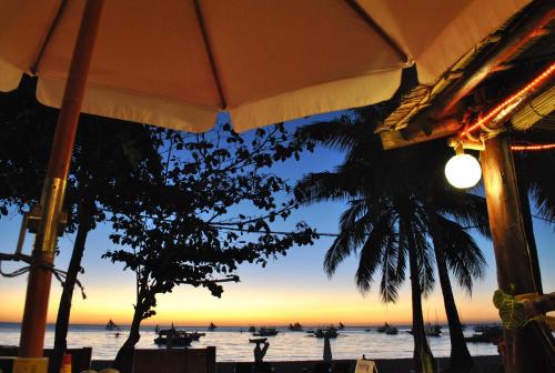 a view of the ocean from a beach with an umbrella at Surfside Boracay Resort in Boracay