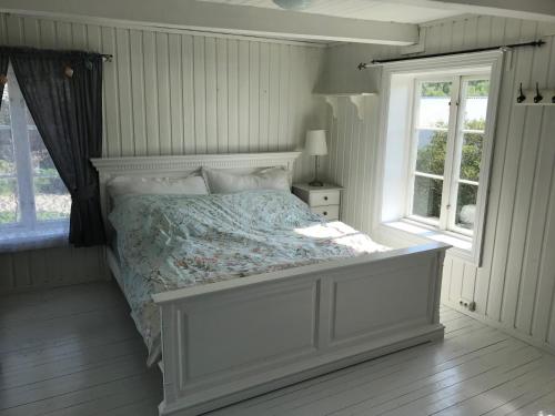 1 dormitorio con 1 cama y 2 ventanas en Rodal Lodge, en Valsøybotn