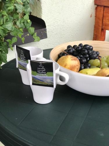 a bowl of fruit and two cups on a table at 4 Seasons Vlašić Lux Apartments in Vlasic
