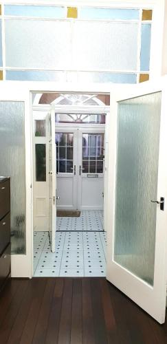 a room with a white door and a tile floor at Gabriel Guesthouse in Rhyl