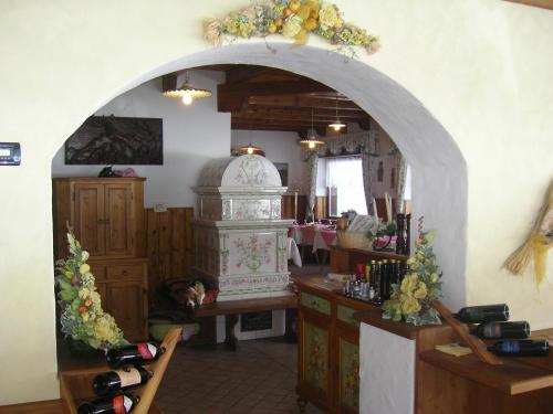 an archway in a room with a counter and a room with wine bottles at Albergo Chalet Lago Antorno in Misurina