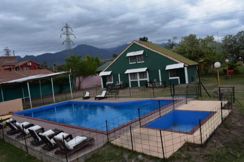 a swimming pool in front of a house at Complejo Solitudine in Cacheuta
