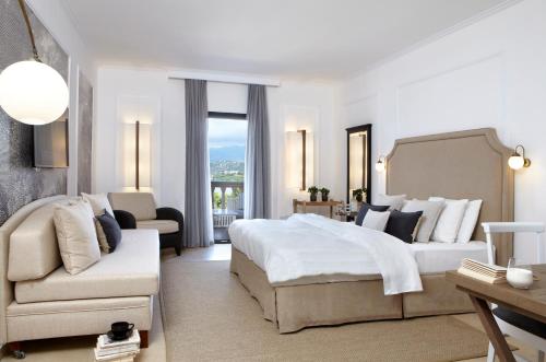 a bedroom with a bed and a couch and a chair at Thalassa Boutique Hotel - Adults Only in Lassi