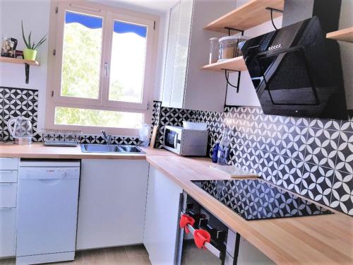 a kitchen with a counter with a sink and a microwave at Chambre privée entre Paris et Disneyland in Noisy-le-Grand