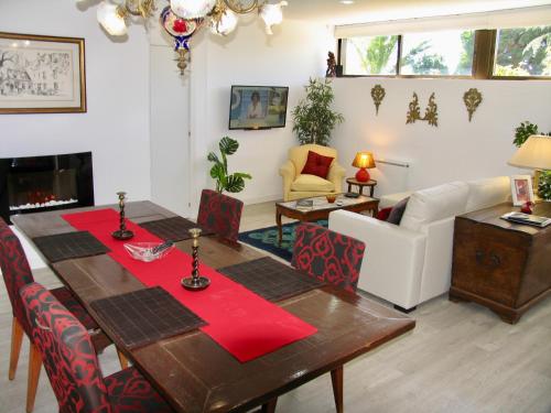 Sala de estar con mesa de comedor y servilletas rojas en MonteLeo Apartment, en Madrid
