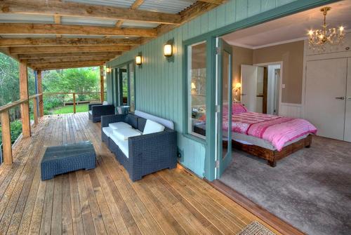 a bedroom with a bed on a wooden deck at Ribbon Gum Lodge in Katoomba