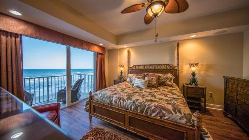 a bedroom with a bed and a balcony with the ocean at Family Friendly - Direct Oceanfront Sanibel 303 in Daytona Beach Shores